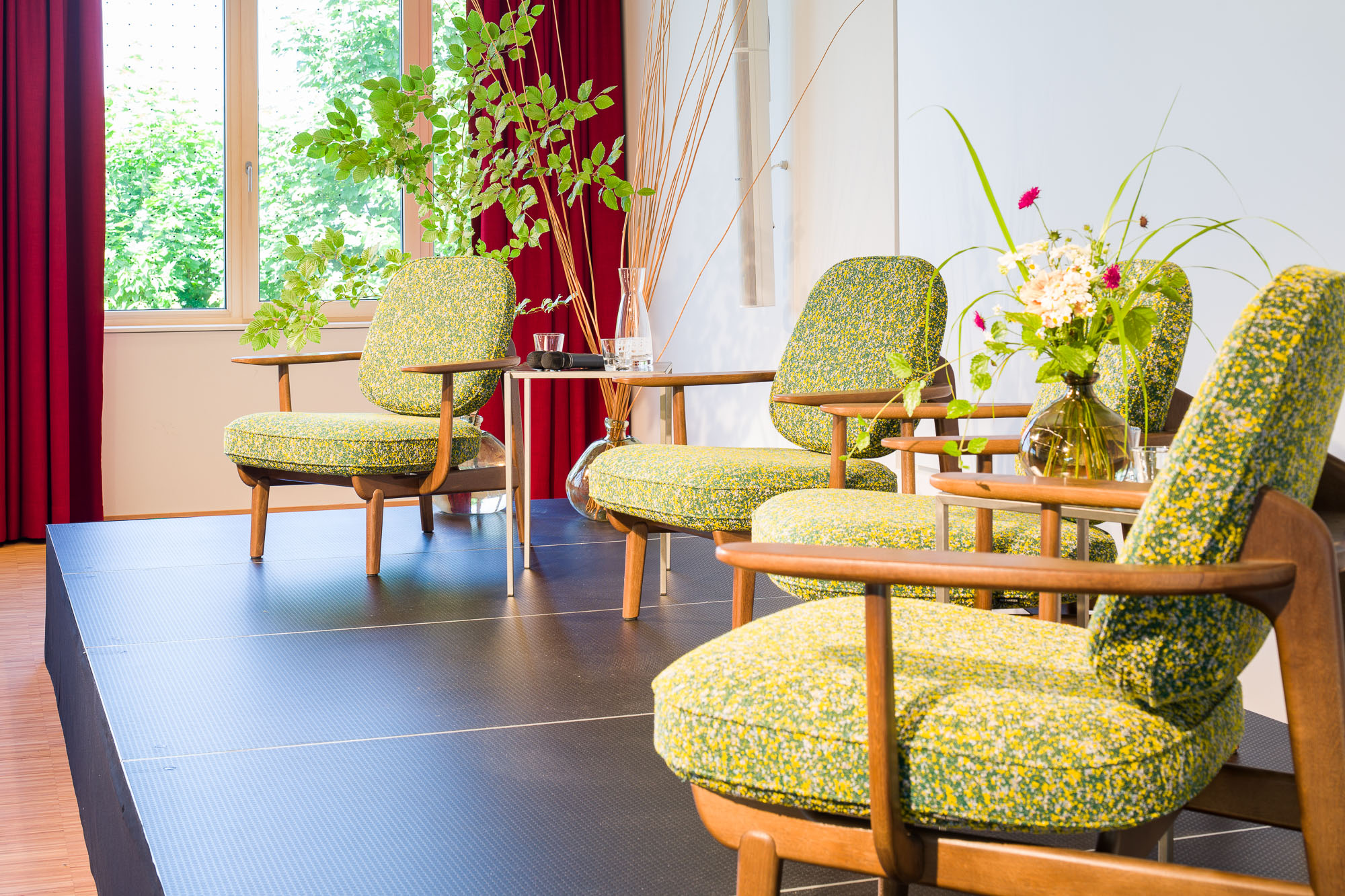 Podium im Saal 2 mit Vortragsbestuhlung und Blumen